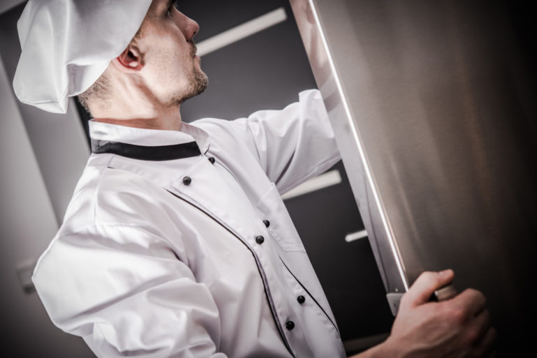 Chef in His 30s Checking on the Fresh Products in the Commercial Restaurant Refrigerator.