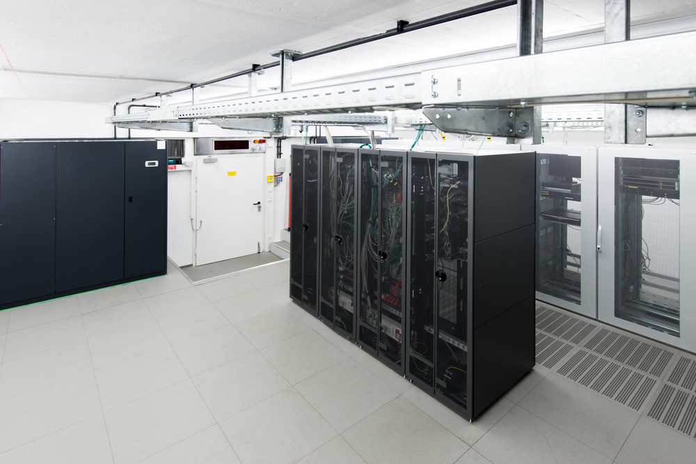 small air conditioned server room with black racks and climate control unit