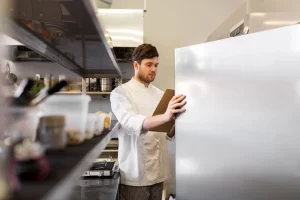 Edmonton technician inspecting a walk-in cooler door seal