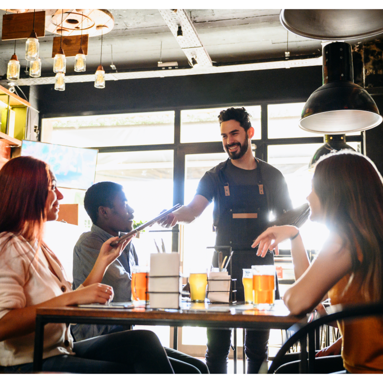 Restaurant server delivering food to guests at a table
